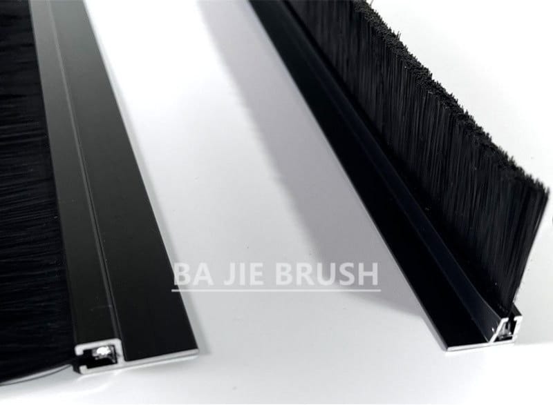 Two black anodised aluminum door seal strip brushes with dense upright black filaments