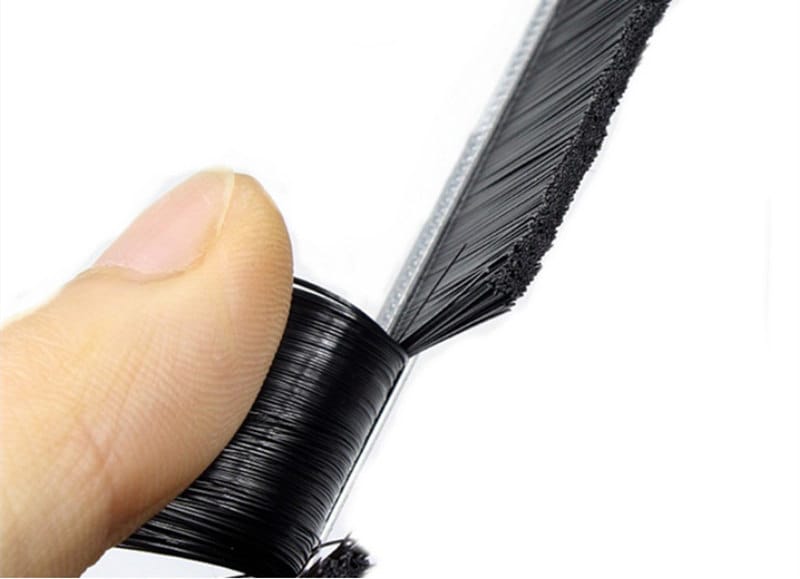 Black strip brush filaments being bent during a manual flexibility check