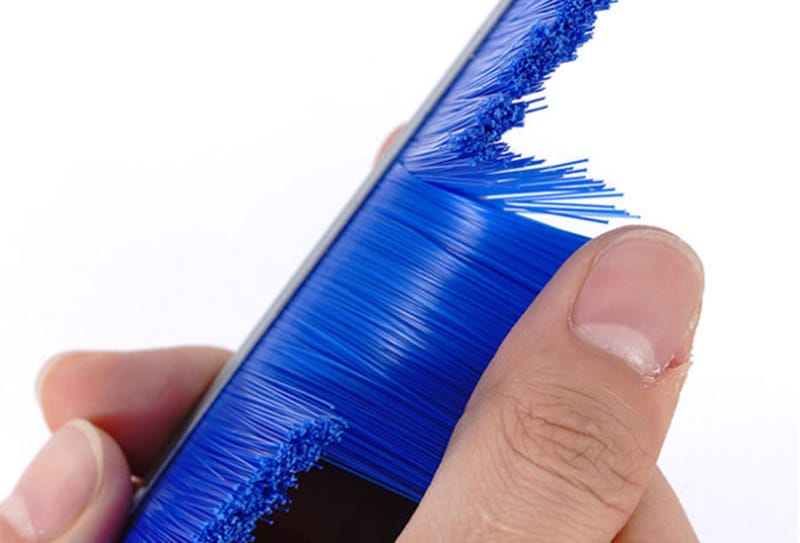 Blue strip brush filaments being bent to demonstrate flexibility and recovery