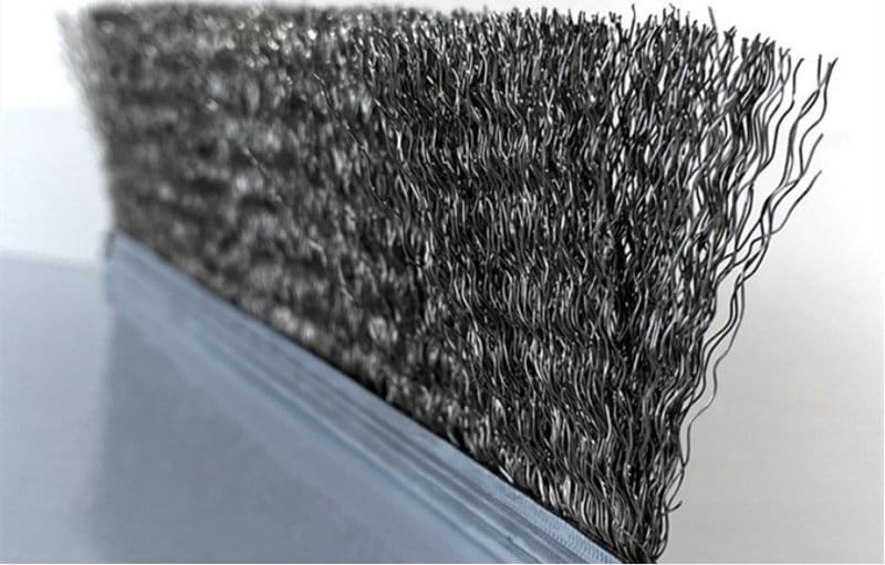 Close-up of densely packed crimped metal wire in a channel strip brush