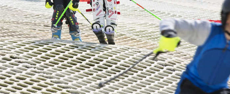 Skiers using a PBT brush mat dry ski slope surface