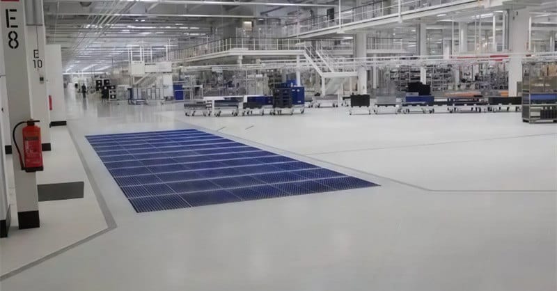 Large wheel cleaning brush mat installed in a factory traffic area