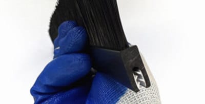 Manual bristle retention check on a black flexible strip brush profile