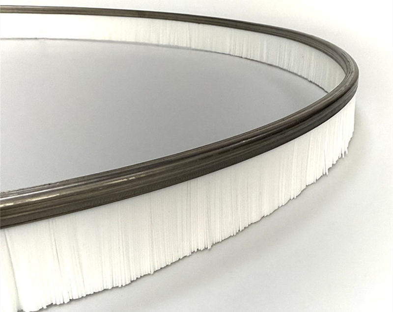 Close-up of white nylon surface cleaner brush with stainless steel support and notched bristle edge